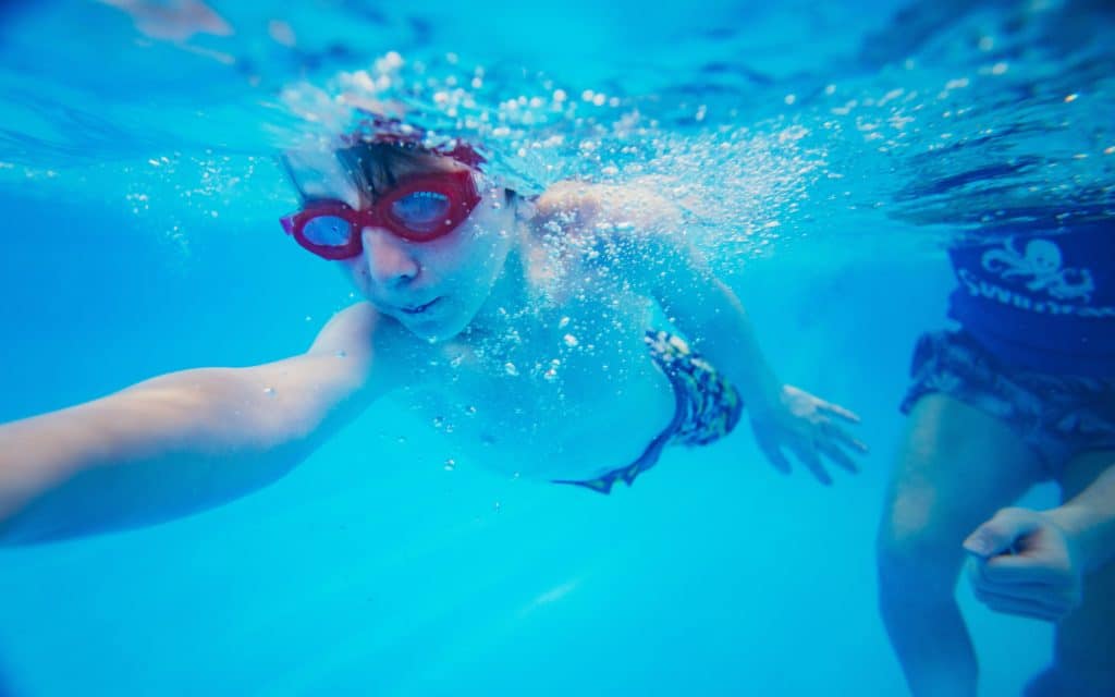 Swimmer Practicing Skills Near Instructor at SwimKids Utah